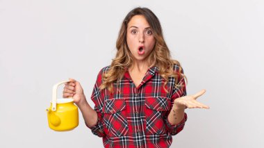 Oldukça zayıf bir kadın şok olmuş, şaşırmış ve elinde bir çaydanlık tutuyor.