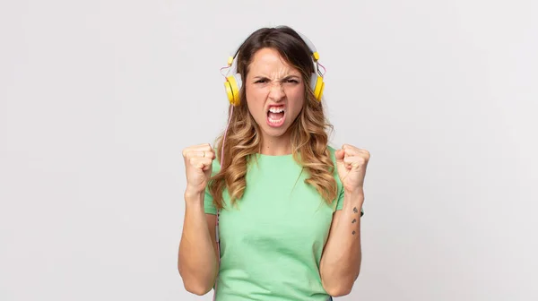 Oldukça Zayıf Bir Kadın Sinirli Bir Ifadeyle Bağırıyor Kulaklıkla Müzik — Stok fotoğraf