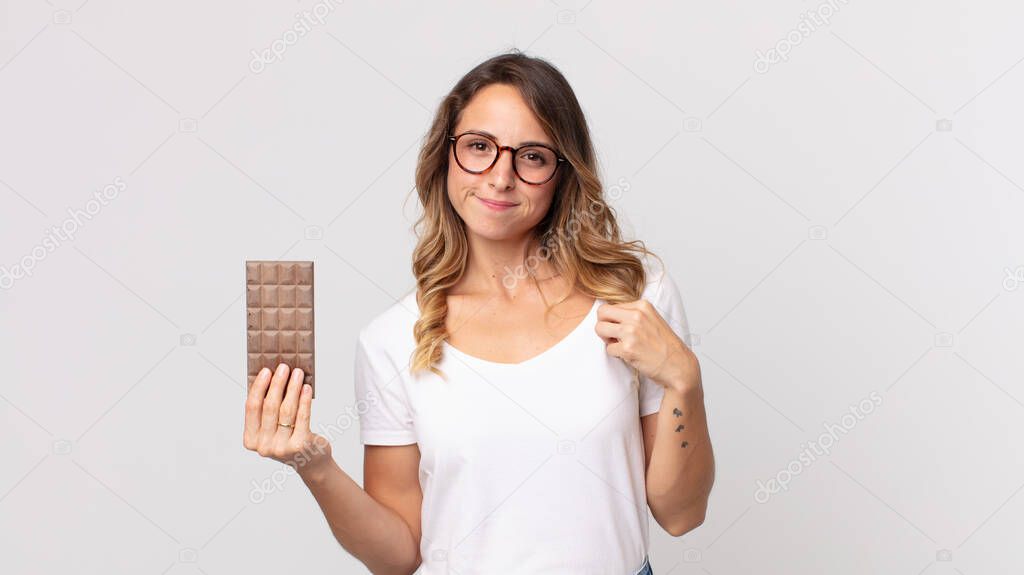pretty thin woman looking arrogant, successful, positive and proud and holding a chocolate bar