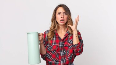 Elleri havada ve elinde kahve termosuyla çığlık atan zayıf bir kadın.