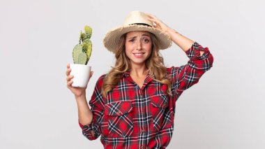 Oldukça zayıf bir kadın kendini stresli, endişeli ya da korkmuş hissediyordu. Elleri başında bir kaktüs tutuyordu. çiftçi kavramı