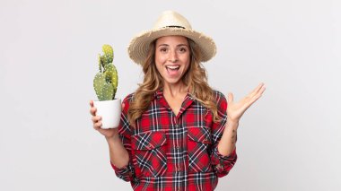 Oldukça zayıf bir kadın kendini mutlu hissediyor ve kaktüs tutan inanılmaz bir şeye hayret ediyor. çiftçi kavramı