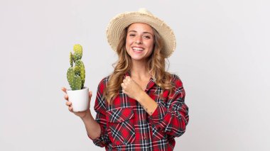 Oldukça zayıf bir kadın kendini mutlu hissediyor ve bir meydan okumayla yüzleşiyor ya da bir kaktüs tutmasını kutluyor. çiftçi kavramı