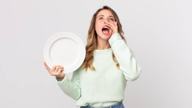 Oldukça zayıf bir kadın kendini mutlu hissediyordu. Elleri ağzının kenarında boş bir tabak tutuyordu ve boş bir tabak tutuyordu.