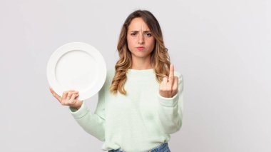 Oldukça zayıf bir kadın kızgın, sinirli, asi ve agresif hissediyor ve elinde boş bir tabakla boş bir tabak tutuyor.