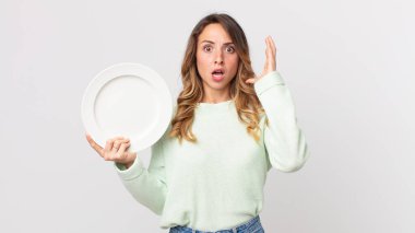 Elleri havada, boş bir tabak tutarak ve boş bir tabak tutarak çığlık atan zayıf bir kadın.