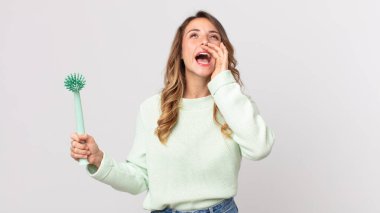 Oldukça zayıf bir kadın kendini mutlu hissediyordu. Elleri ağızında ve bulaşık fırçasıyla bağırıyordu.