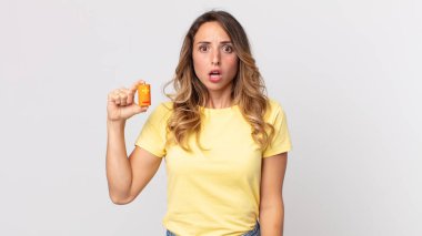 Oldukça zayıf bir kadın şok olmuş ya da şaşırmış görünüyor ve elinde piller var.