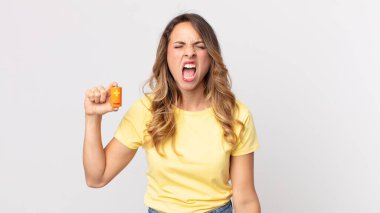 Oldukça zayıf bir kadın saldırganca bağırıyor, kızgın görünüyor ve elinde piller var.