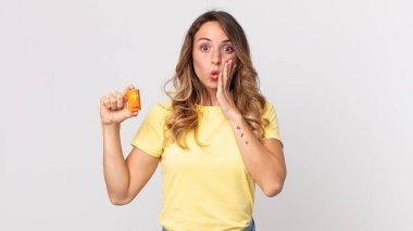 Oldukça zayıf bir kadın şok olmuş, korkmuş ve elinde pil tutuyor.