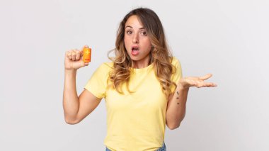 Oldukça zayıf bir kadın şok olmuş, şaşırmış ve elinde pil tutuyor.