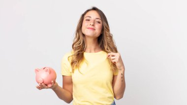 Oldukça zayıf bir kadın kibirli, başarılı, pozitif ve gururlu görünüyor ve elinde bir kumbara tutuyor.