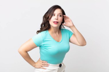 Güzel bir kadın gülümsüyor, tuhaf bir şekilde yan tarafa bakıyor, dedikoduları dinlemeye ya da bir sırrı duymaya çalışıyor.