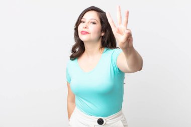 Güzel bir kadın gülümsüyor ve arkadaş canlısı görünüyor. Üç ya da üç numarayı gösteriyor. Elleri önde, geri sayıyor.