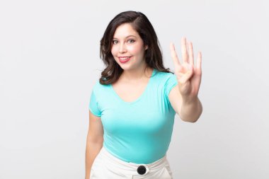 Güzel bir kadın gülümsüyor ve arkadaş canlısı görünüyor, dört ya da dört numarayı gösteriyor, eli önde, geriye doğru sayıyor.