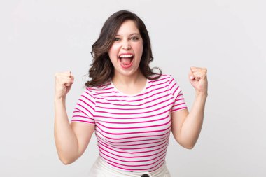 Güzel bir kadın mutlu, şaşırmış ve gururlu, bağırıyor ve başarıyı büyük bir gülümsemeyle kutluyor.