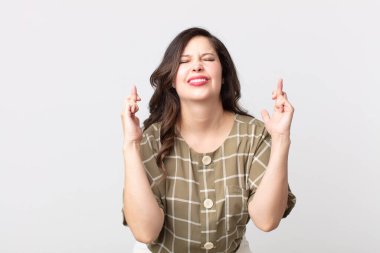 Güzel bir kadın gülümsüyor ve endişeyle iki parmağını çapraz yapıyor. Endişeli ve iyi şanslar diliyor.