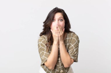 Güzel bir kadın endişeli, üzgün ve korkmuş hissediyor, elleriyle ağzını kapatıyor, endişeli ve berbat görünüyor.