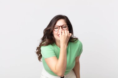 Güzel bir kadın iğreniyor, kötü ve nahoş bir koku duymamak için burnunu tutuyor.