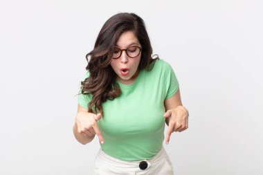 Güzel bir kadın şoke olmuş, ağzı açık ve şaşırmış, inançsızlık ve şaşkınlık içinde bakıyor ve onu işaret ediyor.
