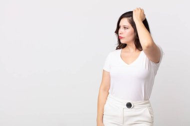 Güzel kadın şaşkın ve kafası karışmış hissediyor, başını kaşıyor ve yan tarafa bakıyor.