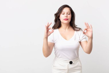 Güzel bir kadın konsantre olmuş ve meditasyon yapıyor, tatmin olmuş ve rahatlamış hissediyor, düşünüyor ya da bir seçim yapıyor.