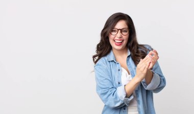 Güzel bir kadın mutlu ve başarılı hissediyor, gülümsüyor ve alkışlıyor, alkışlarla tebrik ediyor.