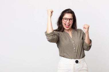 Güzel bir kadın muzaffer bir şekilde bağırıyor, heyecanlı, mutlu ve şaşırmış görünüyor.