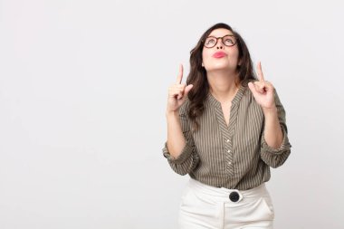 Güzel bir kadın şaşkınlık ve şaşkınlık dolu bir bakışla yukarıyı işaret ederek huşu içinde ve ağzı açık hisseder.
