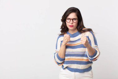 Güzel bir kadın kendinden emin, sinirli, güçlü ve agresif görünüyor. Yumrukları boks pozisyonunda dövüşmeye hazır.