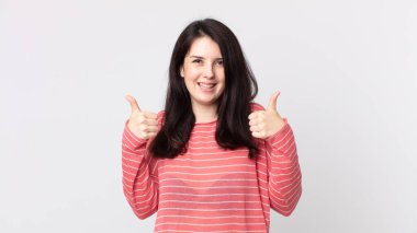 Güzel bir kadın neşeyle gülümsüyor ve mutlu görünüyor, kaygısız ve pozitif hissediyor.