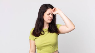 Güzel bir kadın stresli görünüyor, yorgun ve hayal kırıklığına uğramış, alnından ter damlıyor, umutsuz ve bitkin hissediyor.