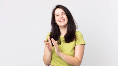 Güzel bir kadın mutlu ve başarılı hissediyor, gülümsüyor ve alkışlıyor, alkışlarla tebrik ediyor.