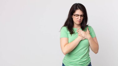 Güzel bir kadın üzgün, incinmiş ve kalbi kırık görünüyor, iki elini de kalbe yakın tutuyor, ağlıyor ve bunalımda.