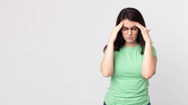 Güzel bir kadın stresli ve hayal kırıklığına uğramış görünüyor, baskı altında çalışıyor, başı ağrıyor ve sorunları var.