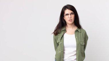 pretty woman feeling puzzled and confused, with a dumb, stunned expression looking at something unexpected