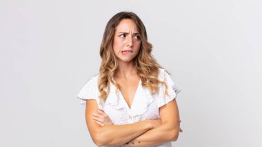 Şüphe eden ya da düşünen, dudağını ısıran, kendine güveni olmayan ve gergin bir kadın.