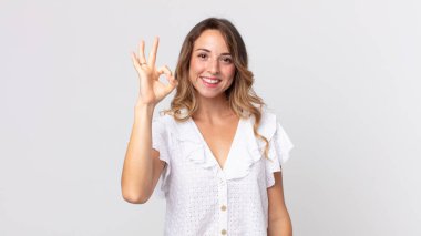 Oldukça zayıf bir kadın kendini mutlu, rahat ve tatmin olmuş hissediyor, iyi bir jestle onaylıyor, gülümsüyor