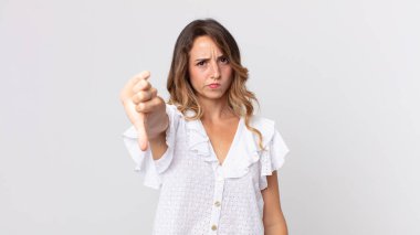 Oldukça zayıf bir kadın kızgın, sinirli, hayal kırıklığına uğramış ya da hoşnutsuz, ciddi bir bakışla başparmaklarını göstermiyor.