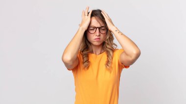 Oldukça zayıf bir kadın stresli ve endişeli, depresif ve hayal kırıklığına uğramış, iki elini de başa kaldırıyor.