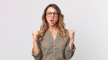 Oldukça zayıf bir kadın kızgın bir ifadeyle ya da yumruklarıyla başarıyı kutlarken agresif bir şekilde bağırıyor.