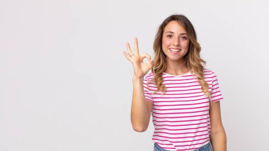 Oldukça zayıf bir kadın kendini mutlu, rahat ve tatmin olmuş hissediyor, iyi bir jestle onaylıyor, gülümsüyor