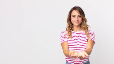 Oldukça zayıf bir kadın mutlu bir şekilde gülümsüyor, arkadaş canlısı, kendine güvenen, olumlu bakışlı, bir nesne ya da konsept sunan ve gösteren