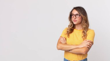 Oldukça zayıf bir kadın omuz silkiyor, kafası karışık ve kararsız, kolları bağlı ve şaşkın görünüyor.