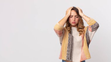 Oldukça zayıf bir kadın stresli ve endişeli, depresif ve hayal kırıklığına uğramış, iki elini de başa kaldırıyor.