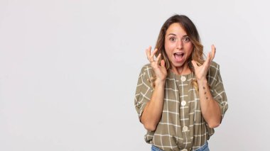 Beklenmedik bir sürpriz yüzünden şaşkın, heyecanlı, gülen, şaşkın ve mutlu bir kadın.