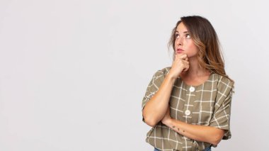 Oldukça ince bir kadın düşünceli, meraklı ya da hayal kuruyor, hayal kuruyor ve uzayı kopyalamak için yukarı bakıyor.