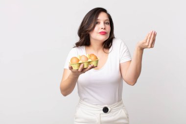 Güzel bir kadın kapiş ya da para hareketi yapıp, sana ödemeni ve yumurta kutusu tutmanı söylüyor.