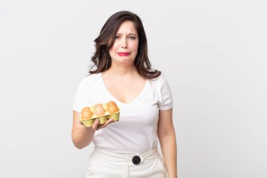 Güzel bir kadın üzgün ve mızmızlanıyor. Mutsuz bir bakışla, ağlıyor ve elinde bir yumurta kutusu tutuyor.