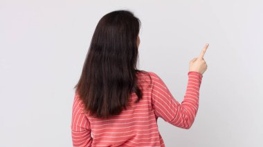 Güzel bir kadın dikey görünüm ve kopya alanı üzerinde duran ve nesneyi işaret eden